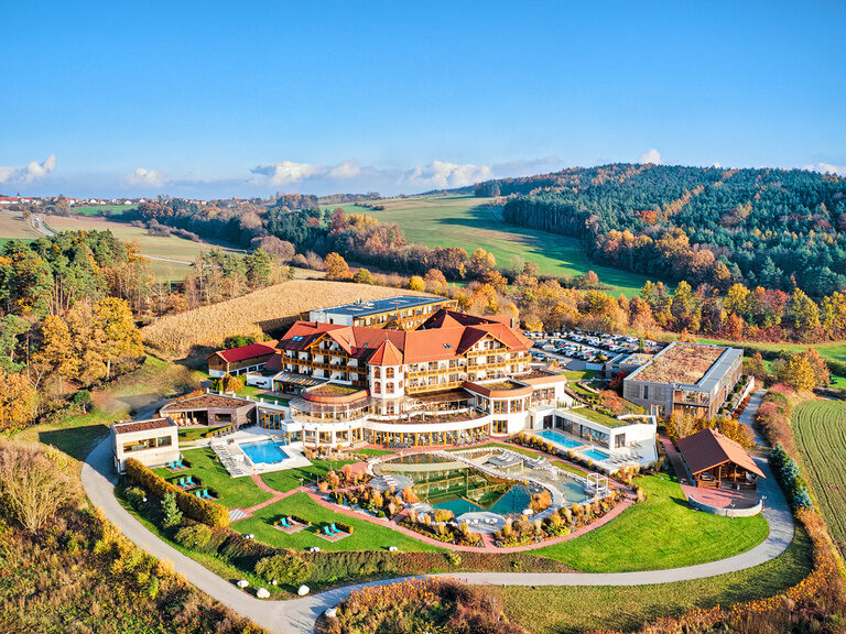 Die Außenansicht des Hotel Der Birkenhof im Sommer umgeben von weitläufigen grünen Flächen.