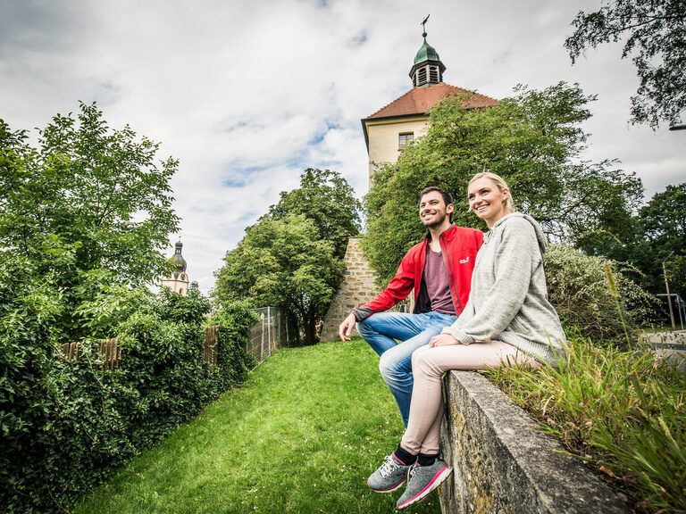 Das Pärchen sitzt auf Mauer vor dem Blasturm in Schwandorf.