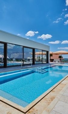 Der blau-weisse bayerische Himmel über dem ruhigen Aussenpool des Hotel Der Birkenhof.