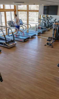 Heller Fitnessraum mit vielen unterschiedlichen Geräten im Fitnessstudio des Wellnesshotel Der Birkenhof.