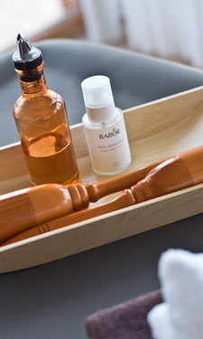 Das Massageöl steht in einer Holzschale im Betula Spa des Hotel Der Birkenhof in Bayern.