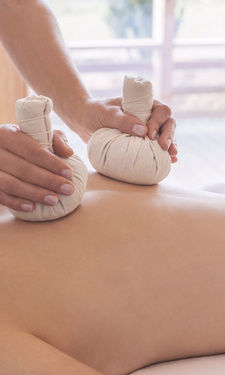 Die wohltuende Ayurveda Massage im Beauty- & Wellnessbereich im Hotel Der Birkenhof wird auf dem Rücken einer Frau vorgenommen.