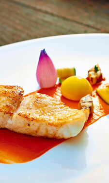 Das farbenfohe Steinbuttgericht elegant mit filigranen Gemüseschnitzereien aus dem Restaurant Eisvogel.