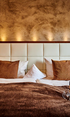 Das großzügige Bett mit stimmungsvoller Beleuchtung in der Turm Suite des Hotel Der Birkenhof.