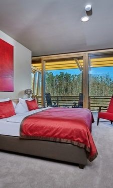 Das Waldstudio im Hotel Der Birkenhof mit gemütlichen Bett und Blick zum Balkon.