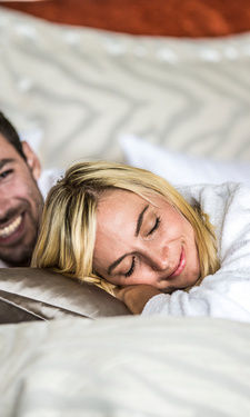 Romantische Zweisamkeit im komfortablen Schlafzimmer inmitten weicher Bettwäsche und eleganten Kissen im Hotel Der Birkenhof..