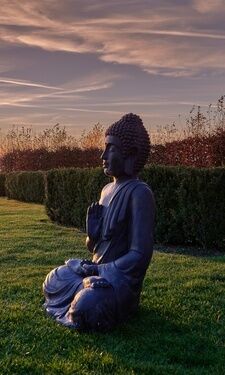 Buddafigur im Sonnenuntergang im Garten des Wellnesshotel der Birkenhof in der Oberpfalz.