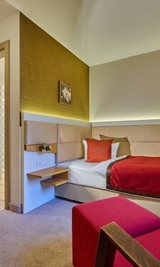 Ein geschmackvoll gestaltetes Komfort Einzelzimmer im Hotel Birkenhof Therme mit einem Bett und einem Schreibtisch.