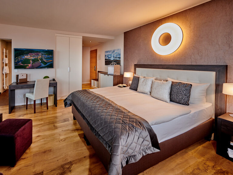 Das gemütliche Bett mit atmosphäre Beleuchtung im Deluxe Doppelzimmers des Hotel Der Birkenhof.