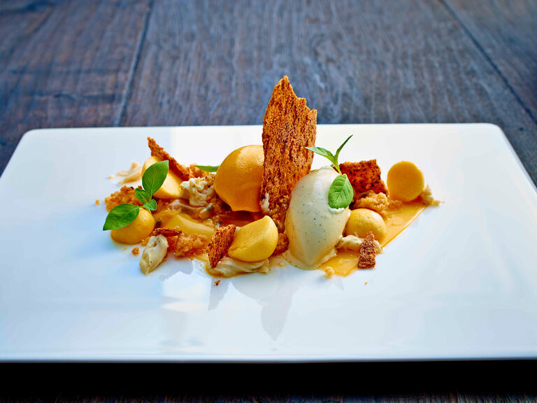 Fein dekorierte Nachspeise mit Vanille- und Passionsfruchteis.