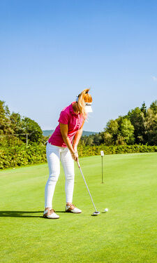 Frau spielt Golf auf großzügige Golfplatz