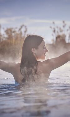 Frau steht im beheizten Außenpool