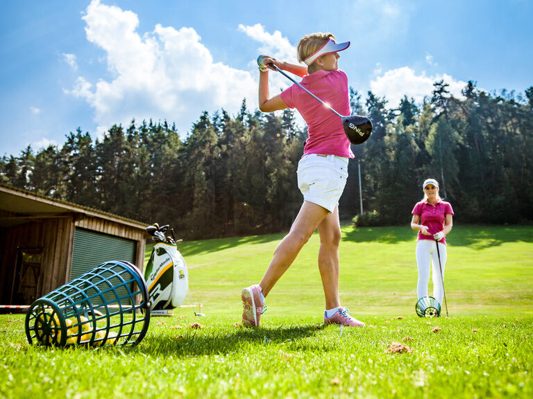 Der schwungvolle Aufschlag einer Frau auf dem Green des Golfplatzes in der Nähe des Hotel Der Birkenhof in der Oberpfalz.