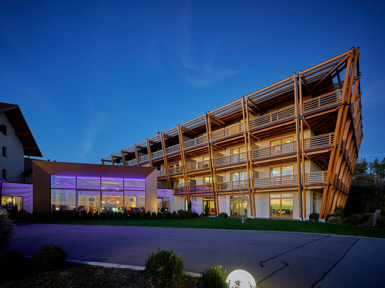 strahlend, modern beleuchteter Hoteleingang des Hotels der Birkenhof in Bayern bei Nacht.