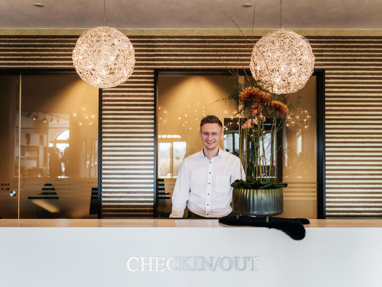 Das freundliche Empfangspersonal checkt Gäste ein, während ein design Licht die Szene erhellt.