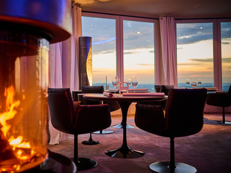 Der gemütliche Kamin im Restaurant bietet einen warmen Platz mit einer herrlichen Aussicht durch die Fensterfront auf einen atemberaubenden Sonnenuntergang.