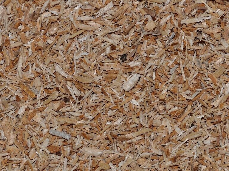 Ein Stapel Holzhackschnitzel, der als nachhaltiger Brennstoff für das nachhaltige Hotel der Birkenhof in Bayern genutzt wird.