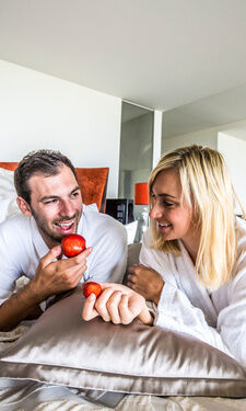 Pärchen ist einen Apfel im Bett