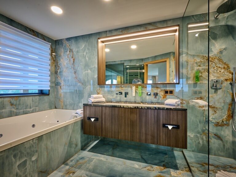 großes Spiegelbad in der Panorama Suite Modern mit Badewanne und Waschbecken im Hotel der Birkenhof beim Bayerischen Wald.