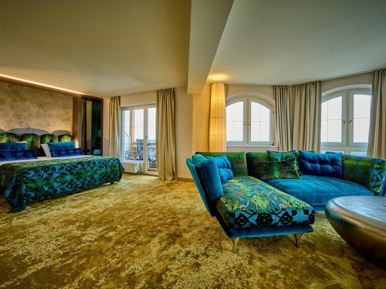 lichtdurchflutete Panorama Suite Modern mit Wohnbereich und einladenden Bett im Hotel der Birkenhof in Bayern.