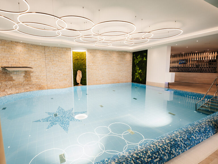 großer Innnenpool im Landhaus Untergeschoss des Wellnesshotels der Birkenhof in der Oberpfalz in einem modernen Poolbereichdesign.