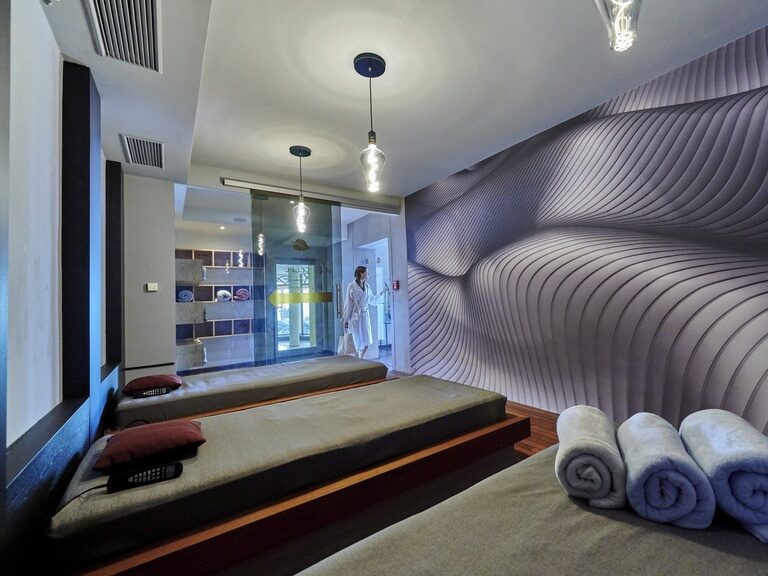 Der Ruheraum mit entspannenen Lichtverhältnissen und einem blau-grauen Raumkonzept im Hotel Der Birkenhof.