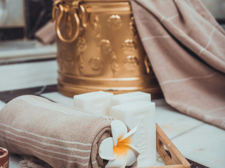 Ein Spa-Tablett mit duftenden Seifen und weichen Handtüchern im Spabereich des Wellnesshotels der Birkenhof.