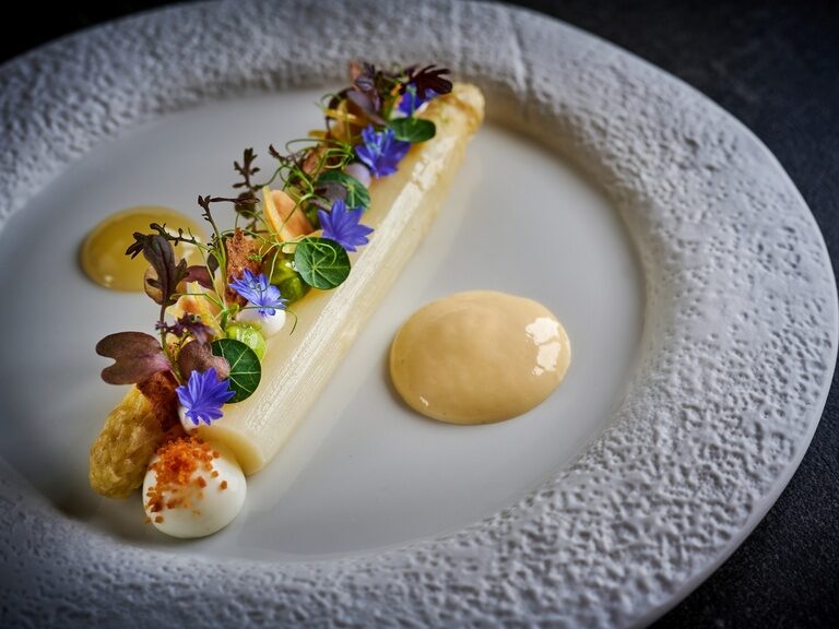 Das elegant angerichtete Spargelgericht mit Blumen und Soßenklecksen aus dem Restaurant Eisvogel.