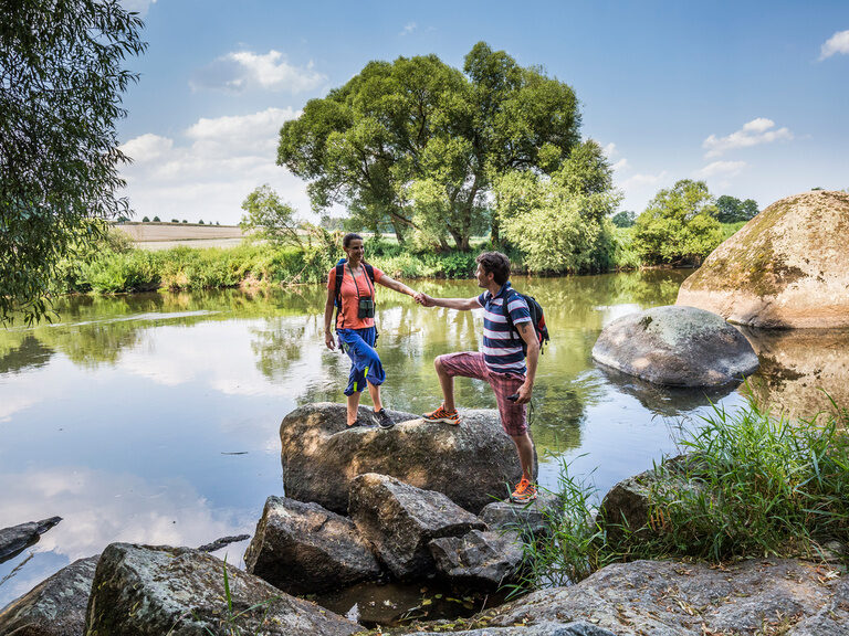 Das Pärchen steht auf einem Stein am Rande eines Sees für eine Pause während der Wanderung auf dem Seenweg.